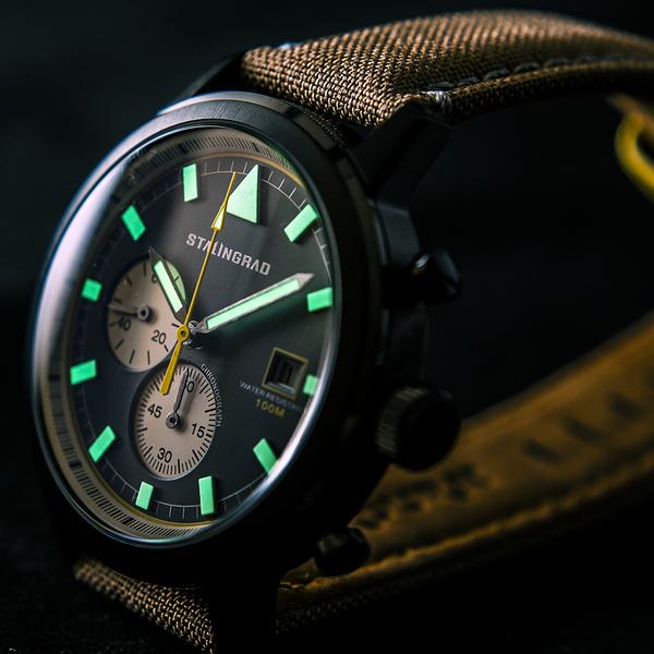 Stalingrad trooper chronograph watch with SUPER-LUMINOVA lume lighting up the hands and hour markers, diagonal view on a dark background 