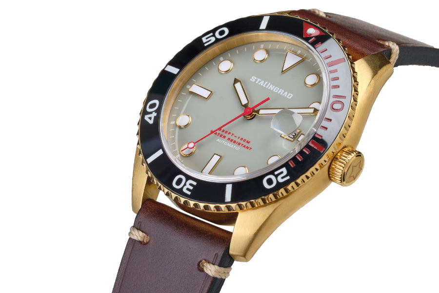 Stalingrad Volga defender automatic watch with a gold case and grey colour dial with red second hand in a brown leather strap, diagonal view or watch on a white background